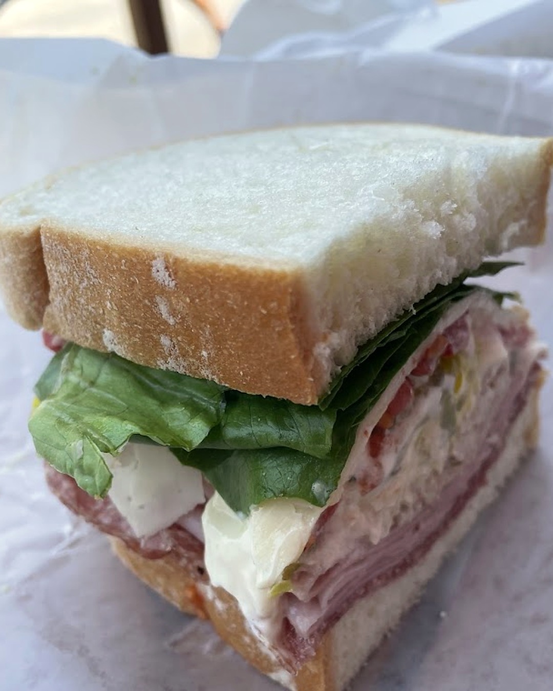 Italian-style sandwich on white bread with cured meats, fresh mozzarella and lettuce