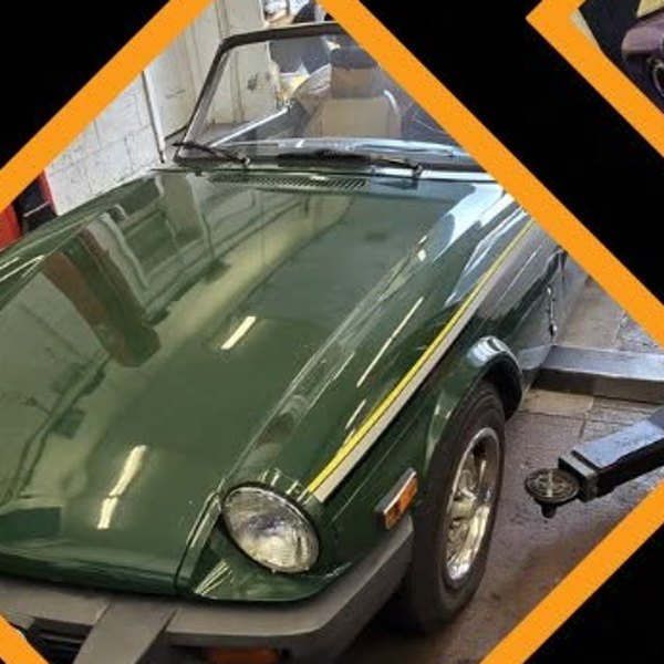 A classic green convertible roadster being serviced at JK Motors